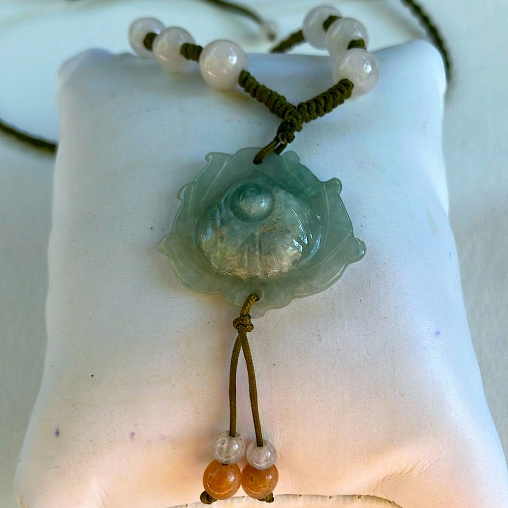 Carved jade pendant and carnelian and moonstone beads on twisted cord necklace.